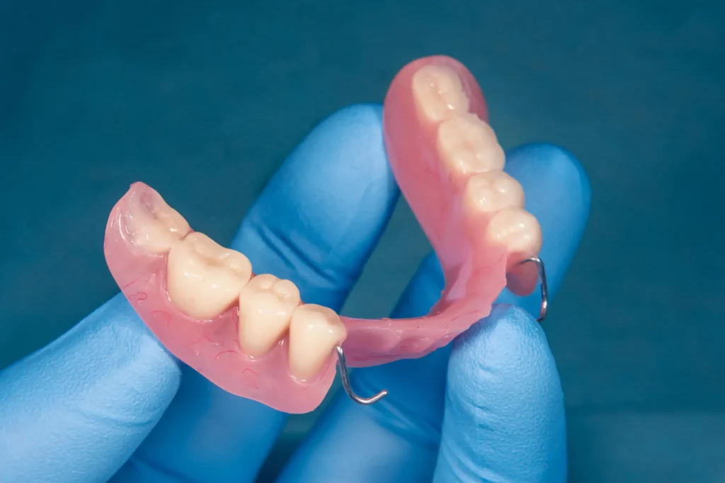 dentist holding emergency partial dentures naples