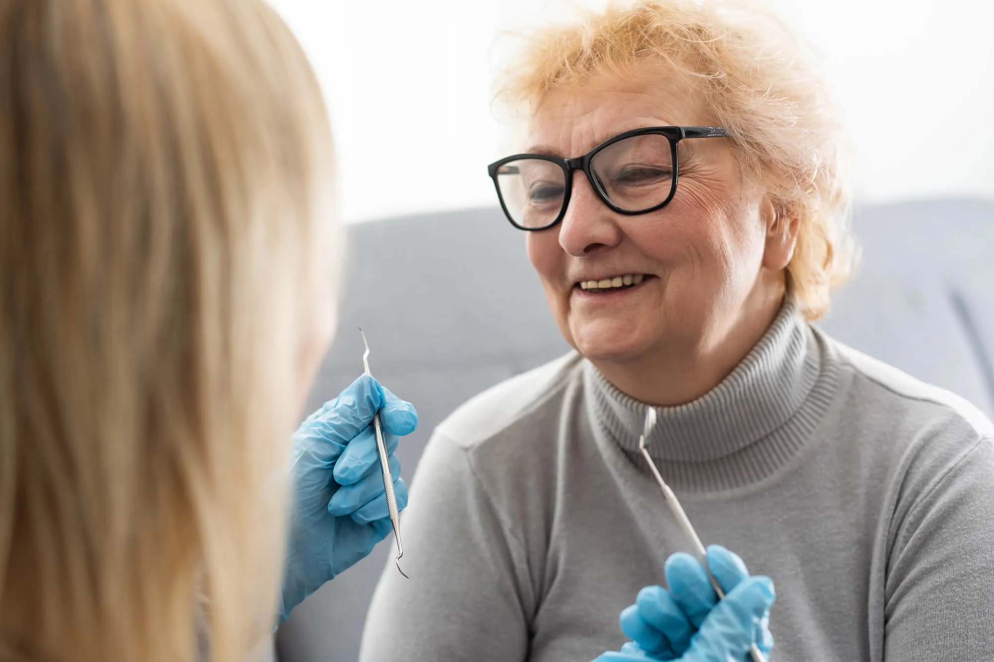 dentist assessing patient's dental implants naples